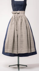 Nahaufnahme Dirndlschürze aus naturfarbenem Bio-Leinen mit eingewebtem Muster – Frontansicht auf Büste, nachhaltig gefertigt von Zirbenfux