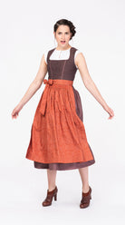 Dirndlschürze aus Baumwolle in Orange-Terrakotta – am Model in Bewegung, nachhaltig gefertigt von Zirbenfux