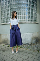 Hosenrock Audrey mit Bluse Romy im Set in Blau aus Leinen, Model locker stehend in Frontansicht auf der Straße im urbanen Setting, klar inszeniert von Zirbenfux.