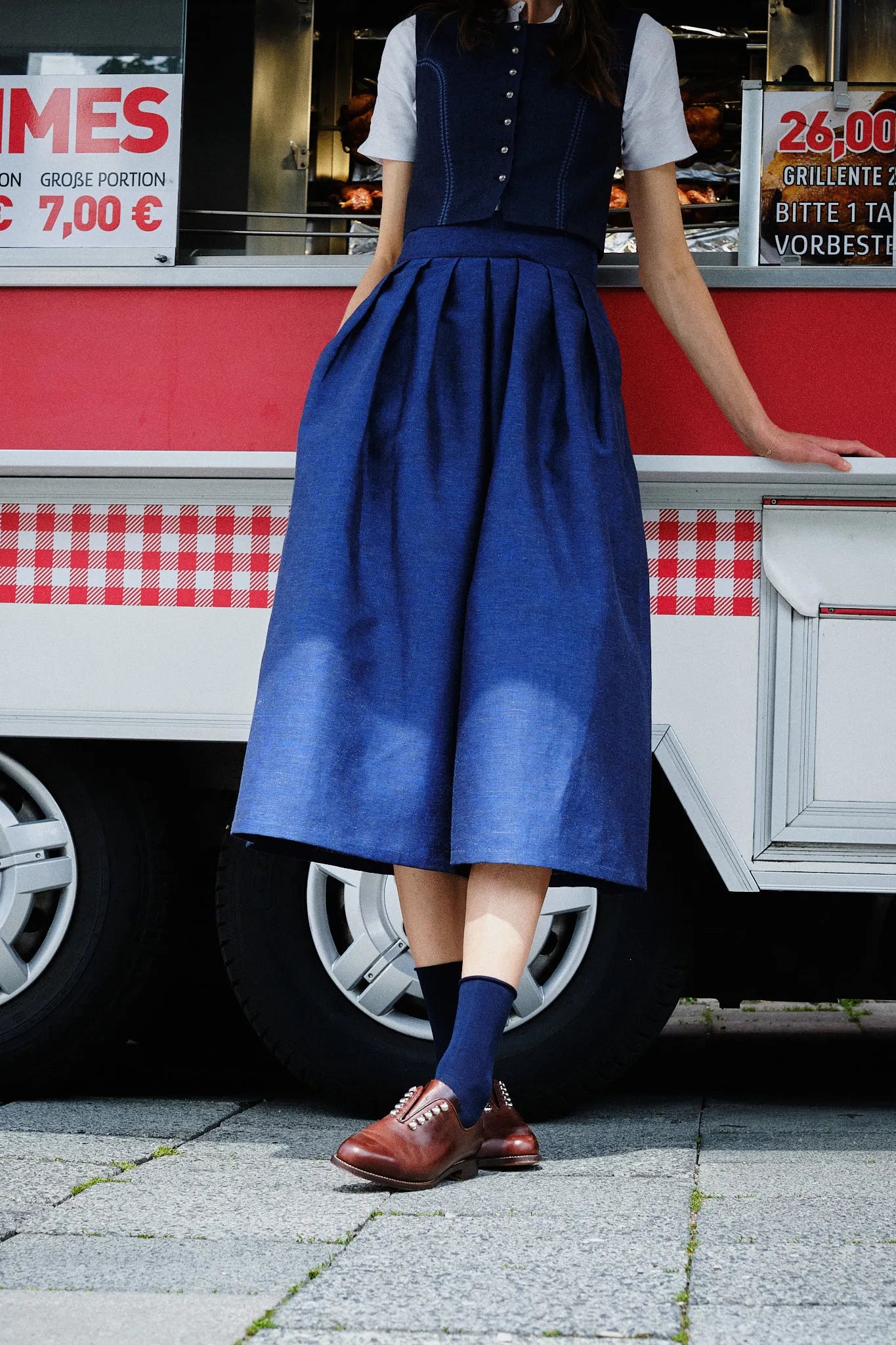 Hosenrock Audrey mit Fuxerl Charlie im Set in Dunkelblau aus Leinen, Detailansicht des Hosenrocks im urbanen Umfeld vor einem Straßenimbiss, lässig getragen, inszeniert von Zirbenfux.