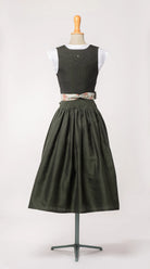 Mieder Ava aus dunkelgrüner Leinen-Schurwolle-Mischung, kombiniert mit Schürze mit Blumenmuster – Rückansicht auf Büste, handgefertigt in München von Zirbenfux