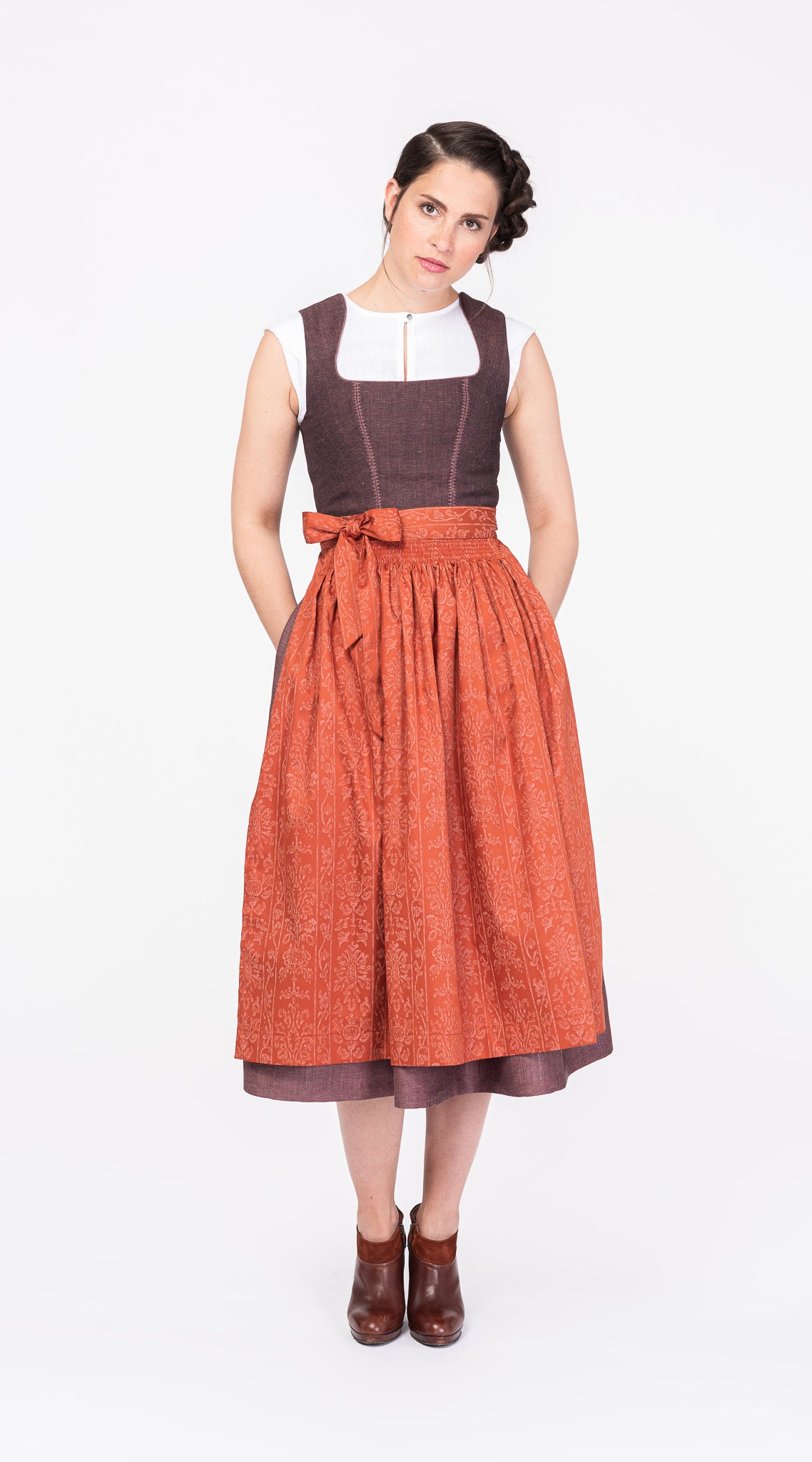 Mieder Ava aus Leinen-Schurwolle-Mischung in Malve, kombiniert mit Rock Marlene und Baumwollschürze in Terrakotta – Frontansicht am Model, modern interpretiert und handgefertigt in München von Zirbenfux