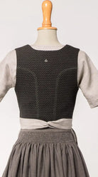 Mieder Ava aus Schurwolle in Schwarz, Rückansicht auf Büste mit feinem Webmuster, präsentiert von Zirbenfux.