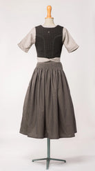 Mieder Ava aus schwarzer Schurwolle mit Webmuster, kombiniert mit Rock Marlene und naturfarbener Leinenschürze – Rückansicht auf Büste, handgefertigt von Zirbenfux