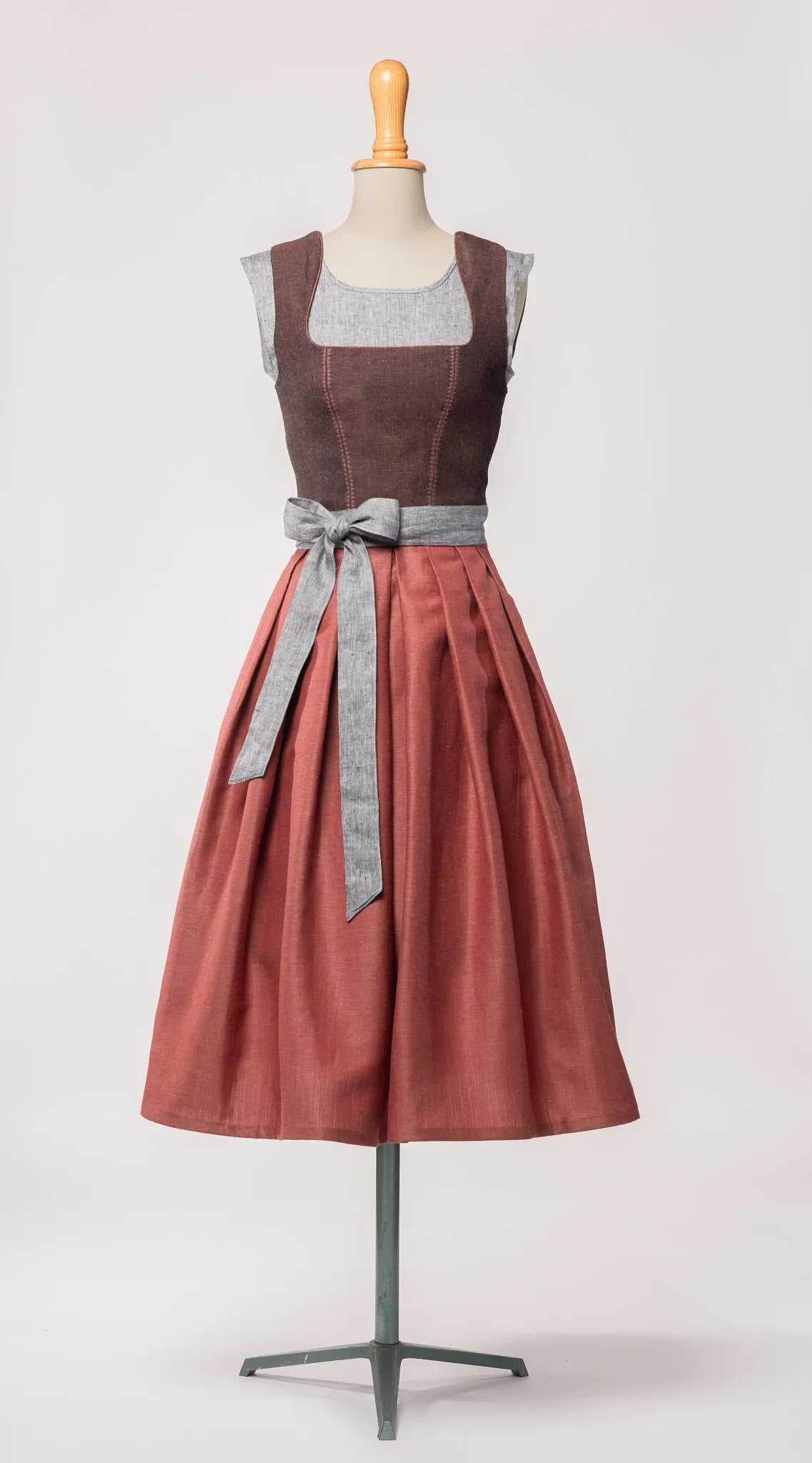 Schürzenband aus blaugrauem Bio-Leinen – kombiniert mit Mieder in Brombeere und Rock in pinker Beere, Frontansicht auf Büste, moderne Tracht von Zirbenfux