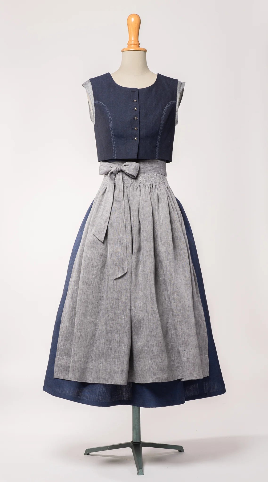 Trachtenrock Marlene aus dunkelblauer Leinen-Schurwolle-Mischung, kombiniert mit farblich passendem Fuxerl Charlie und Schürze aus blaugrauem Bio-Leinen – Frontansicht auf Büste, handgefertigt in München von Zirbenfux