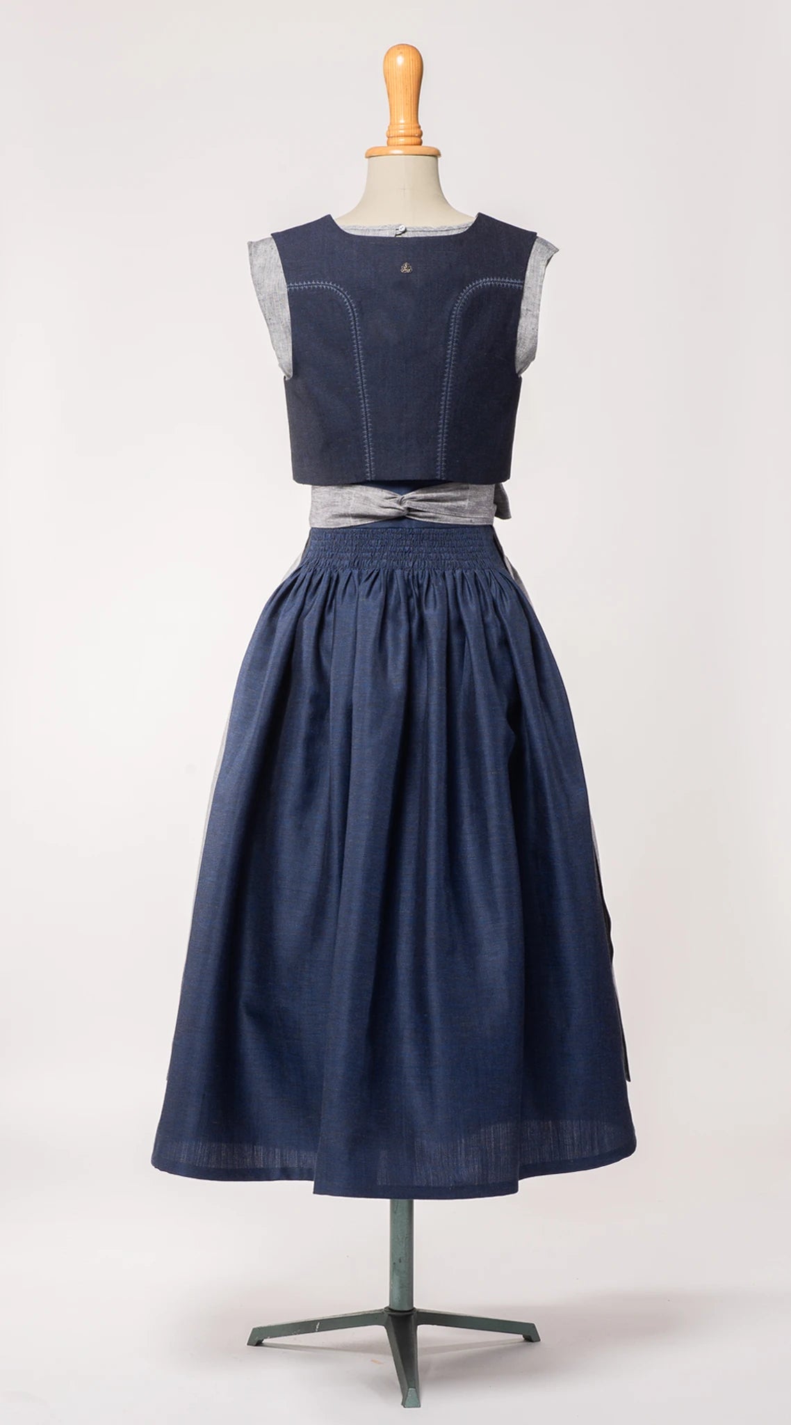Trachtenrock Marlene aus dunkelblauer Leinen-Schurwolle-Mischung, kombiniert mit farblich passendem Fuxerl Charlie und Schürze aus blaugrauem Bio-Leinen – Rückansicht auf Büste, handgefertigt von Zirbenfux