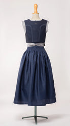 Trachtenrock Marlene aus dunkelblauer Leinen-Schurwolle-Mischung, kombiniert mit farblich passendem Fuxerl Charlie und Schürze aus blaugrauem Bio-Leinen – Rückansicht auf Büste, handgefertigt von Zirbenfux