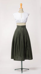 Trachtenrock Marlene aus dunkelgrüner Leinen-Schurwolle-Mischung, kombiniert mit Dirndlbluse Tilda aus weißem Bio-Leinen – Frontansicht auf Büste, handgefertigt von Zirbenfux