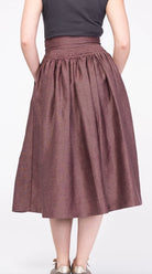 Trachtenrock Marlene aus Leinen in Farbe Malve – Rückansicht am Model, nachhaltig gefertigt von Zirbenfux