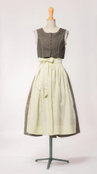 Trachtenrock Marlene aus gold-naturfarbener Leinen-Schurwolle-Mischung, kombiniert mit Fuxerl Charlie und buttergelber Leinenschürze – Frontansicht auf Büste, handgefertigt in München von Zirbenfux