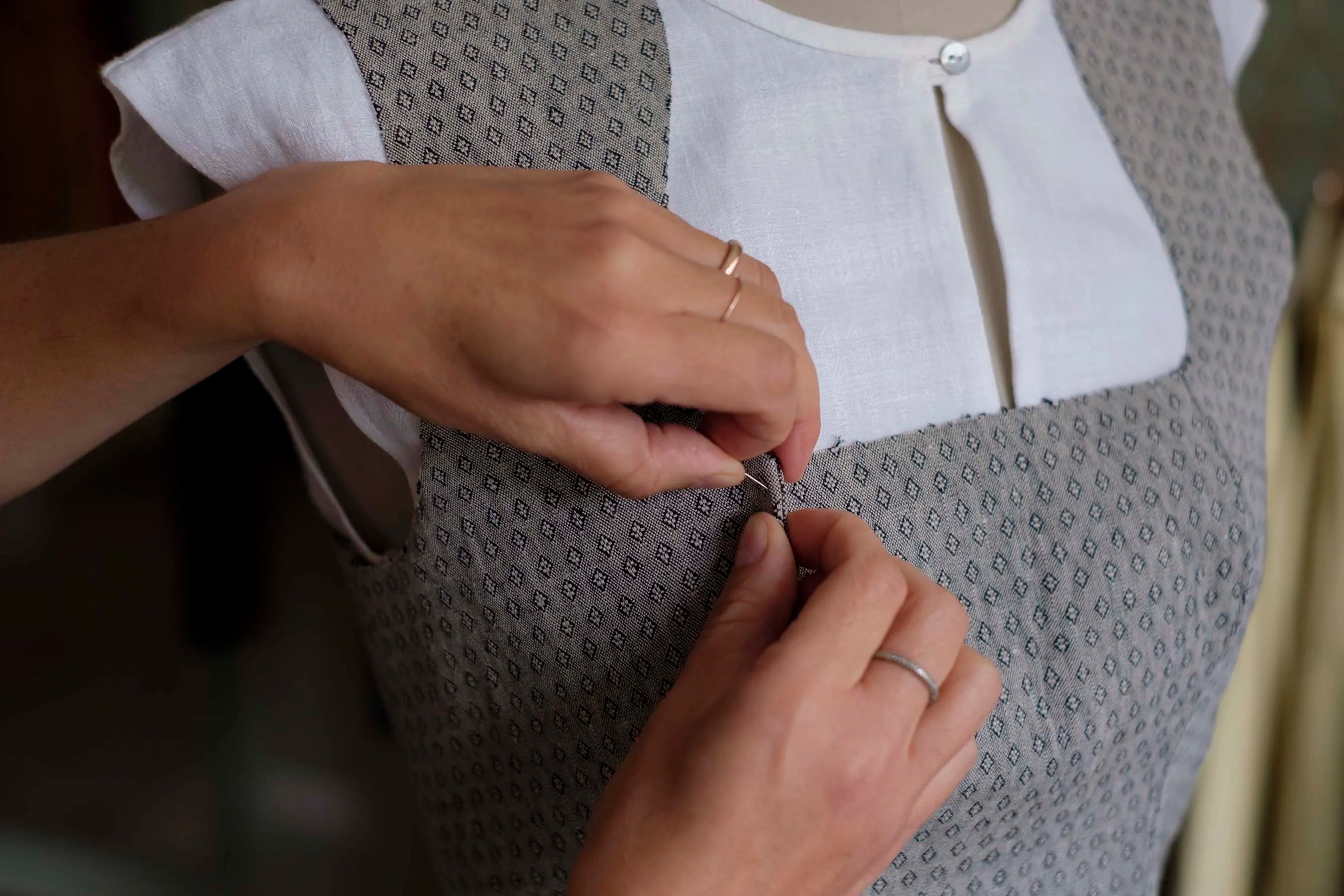 Atelierszene in München, Mieder wird in Nahaufnahme für die Maßanfertigung abgesteckt.